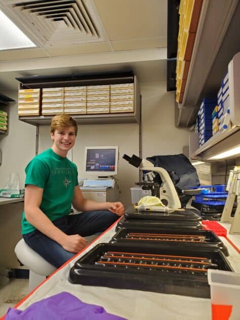Sam Dauby sits in a lab at the Department of Pathology at the University of Pittsburgh.