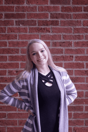 W&J senior Brianna Bray poses in front of a brick wall.