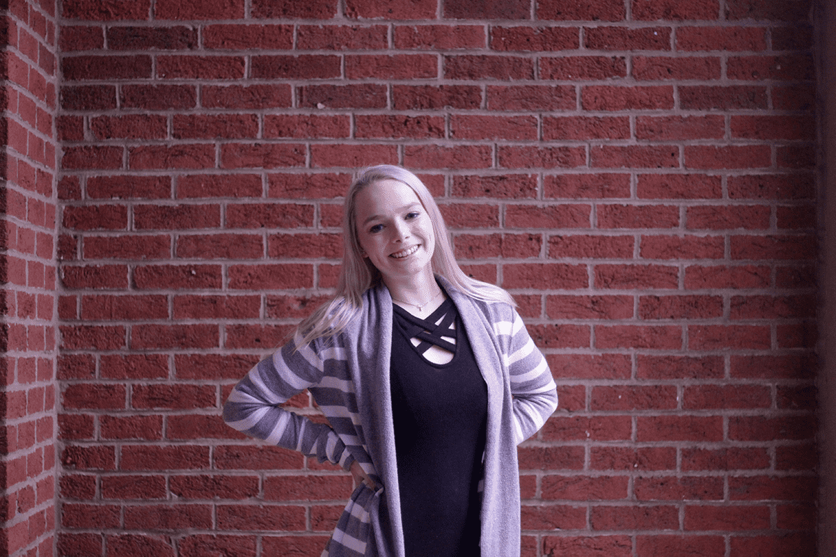W&J senior Brianna Bray poses in front of a brick wall.