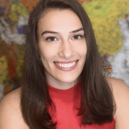 Clara Sherwood poses in front of a world map.