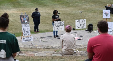 W&J BSU President Tamia Mickens '21 speaks surrounded by signs promoting racial justice at the BSU's Celebration of Black Life, held in the amphitheater on W&J's campus.