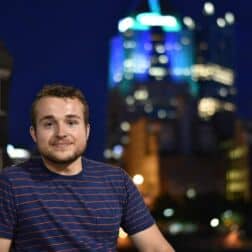 Noah Hoffman poses in front of the Pittsburgh skyline.