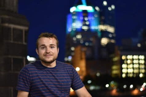 Noah Hoffman poses in front of the Pittsburgh skyline.