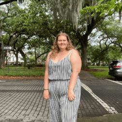 W&J senior Jillian Curtis stands and smiles in front of trees.