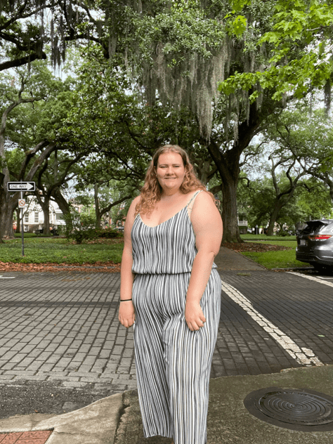 W&J senior Jillian Curtis stands and smiles in front of trees.