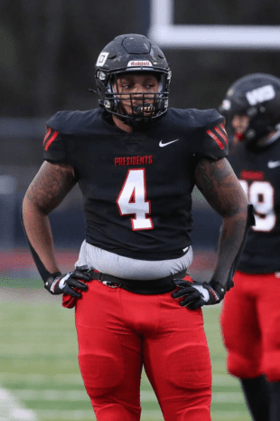 W&J alumnus Keith Knowell '21 stands in uniform on football field.