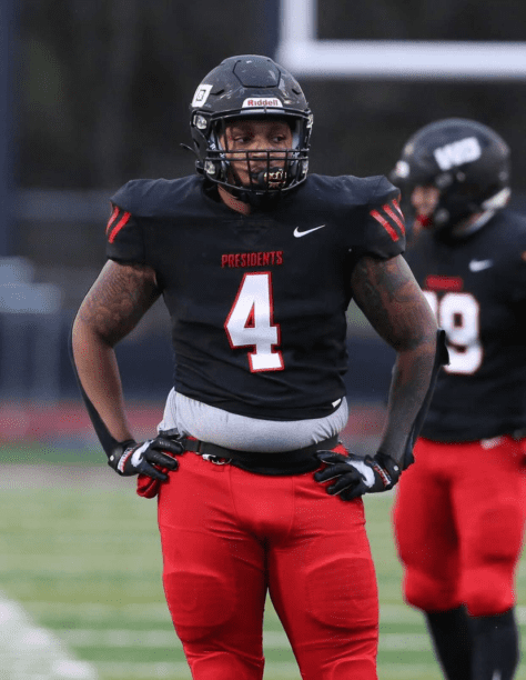 W&J alumnus Keith Knowell '21 stands in uniform on football field.