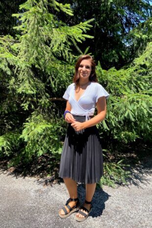 W&J senior Kyleigh Jester stands in front of an evergreen tree and smiles.