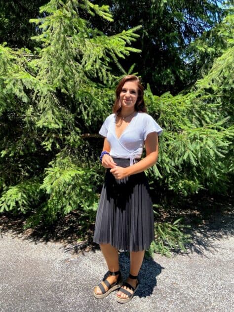 W&J senior Kyleigh Jester stands in front of an evergreen tree and smiles.