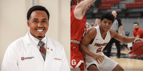 Alumnus Kenny Clark smiles while junior Kyran Mitchell fends off a basketball opponent.