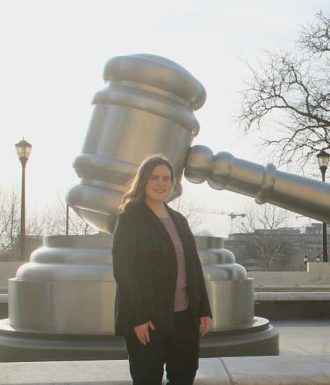 W&J Senior Natalie McBride stands in front of a sculpture of a gavel.