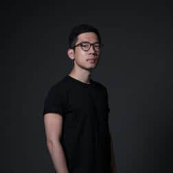 Nathan Law wearing a black tshirt standing against a dark background