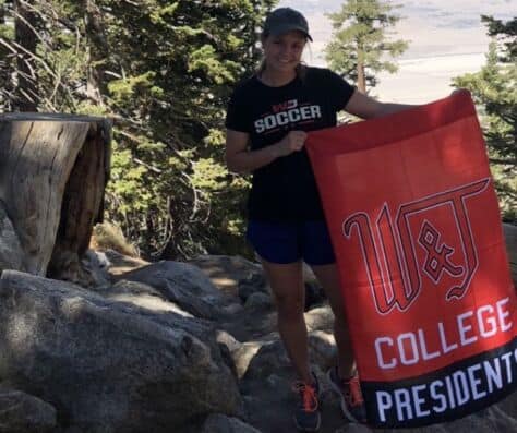 Brianna McGowan stops on a hike to pose with a W&J flag.