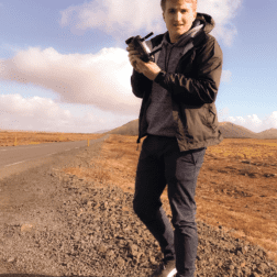 W&J student Robert Kaiser stands in desert holding a mechanical device.
