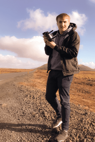 W&J student Robert Kaiser stands in desert holding a mechanical device.