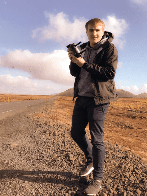 W&J student Robert Kaiser stands in desert holding a mechanical device.