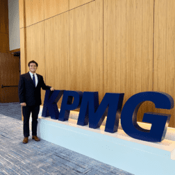 W&J junior Ryan Coughenour stands next to giant KPMG letters.