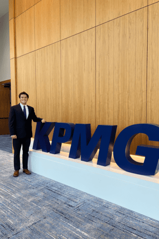 W&J junior Ryan Coughenour stands next to giant KPMG letters.