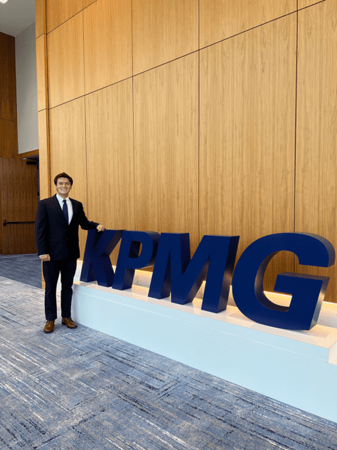 W&J junior Ryan Coughenour stands next to giant KPMG letters.