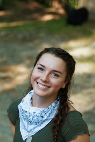 W&J senior Shayla Watkins stands among greenery and smiles.