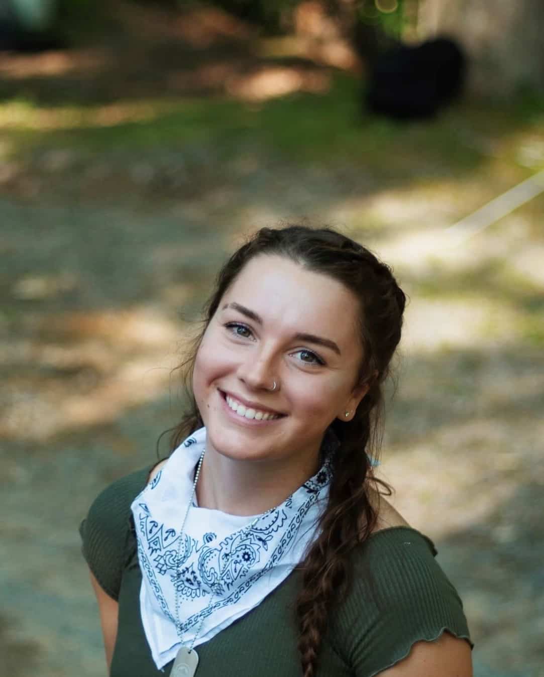 W&J senior Shayla Watkins stands among greenery and smiles.