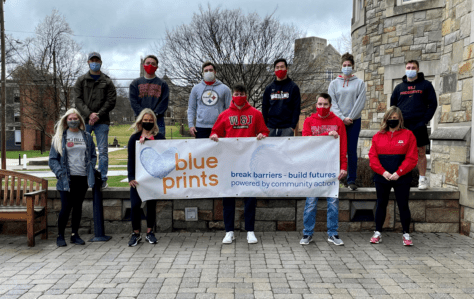 Student participants in the VITA tax program pose with a banner for Blue Prints, the organization through which they are offering tax services.