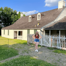 W&J rising senior Ana Giampa stands with her hands on her hips in front of the historic Woodville home in Bridgeville, Pa.