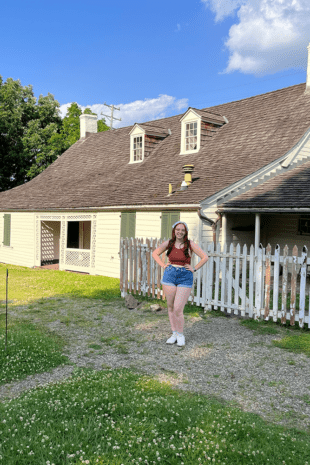 W&J rising senior Ana Giampa stands with her hands on her hips in front of the historic Woodville home in Bridgeville, Pa.