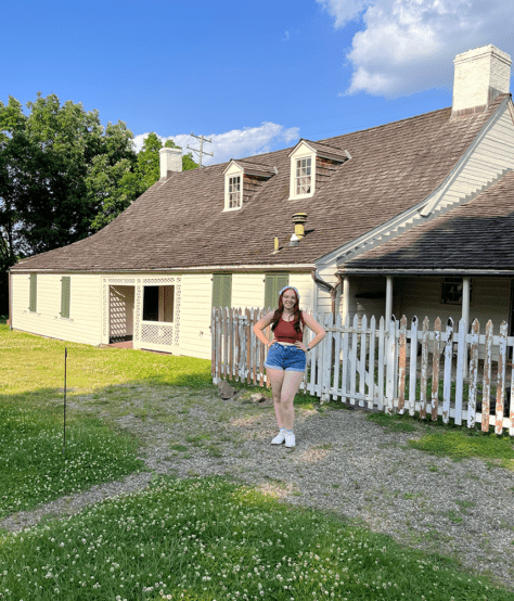 W&J rising senior Ana Giampa stands with her hands on her hips in front of the historic Woodville home in Bridgeville, Pa.