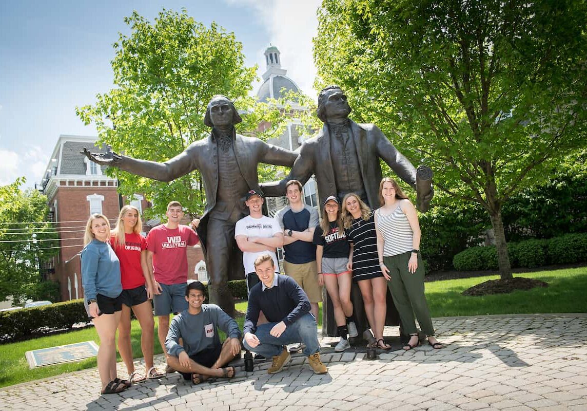 Photo of students standing in front of W&J's statues of George Washington and Thomas Jefferson.