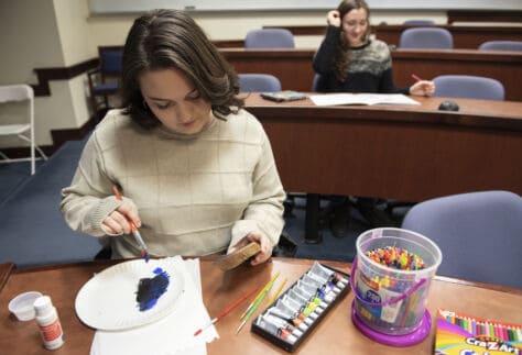 Students in Coloring Club during a December meeting paint and color.