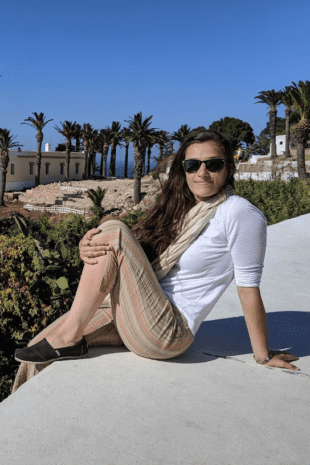 W&J alumna Clara Sherwood poses on a ledge overlooking the sea in Morocco.