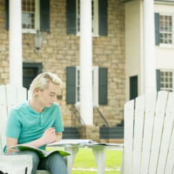 Student reading in Adirondack chairs on campus during the Creosote Affects photo shoot May 1, 2019 at Washington & Jefferson College.