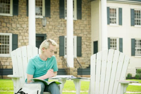 Student reading in Adirondack chairs on campus during the Creosote Affects photo shoot May 1, 2019 at Washington & Jefferson College.