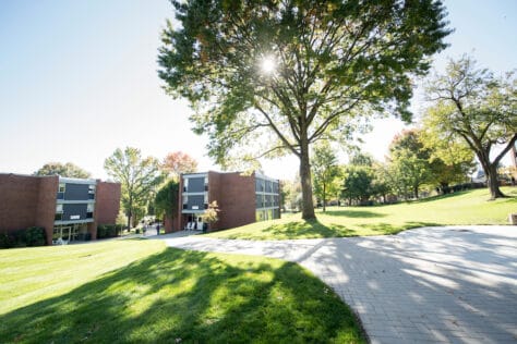 Students walk on campus with Presidents Row residence halls Fillmore Hall and Monroe Hall as seen October 21, 2019 during the Creosote Affects photo shoot at Washington & Jefferson College.