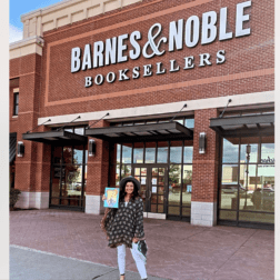 Jacqueline Manina poses in front of a Barnes and Noble store holding her book.