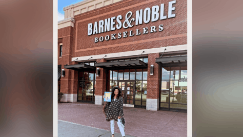 Jacqueline Manina poses in front of a Barnes and Noble store holding her book.
