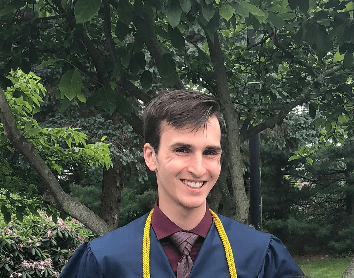 W&J senior Bryton Altenbach smiles in front of greenery.