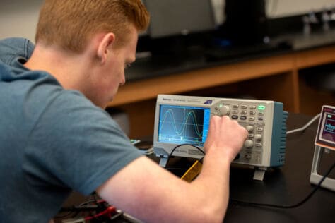 Brannon Boyd works on a machine in Dr. Mike McCracken's electronic lab