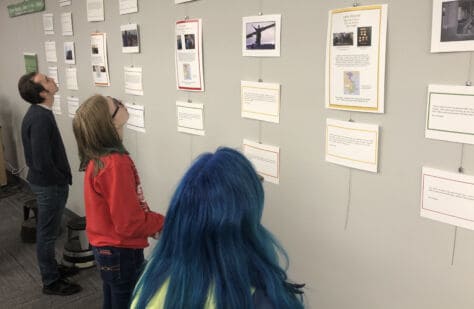 Students look at the exhibit "Ever Veteran Has A Story" based on student interviews with Vietnam Veterans in Clark Family Library.
